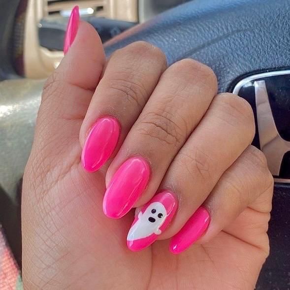 Playful Pink Nail Art: Glossy Elongated Shapes with Whimsical Ghost Accent for Festive Fun.