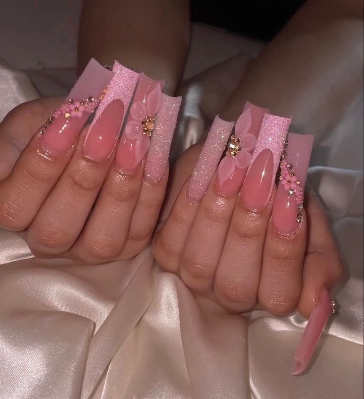 Chic Nail Art: Glossy Pink Design with Sparkling Accents and Floral Details.