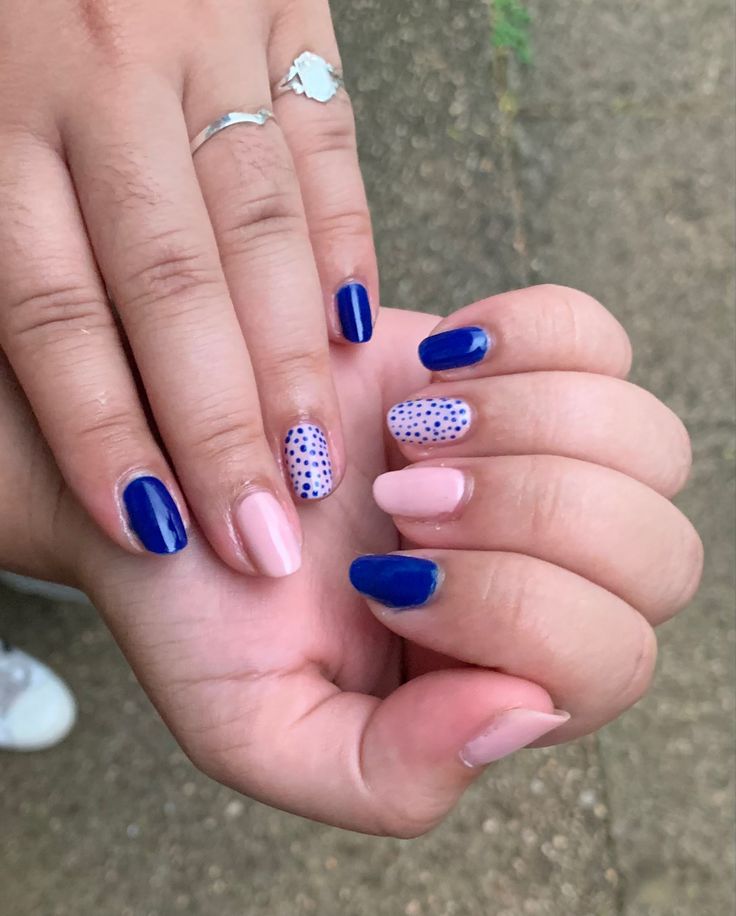 Stylish Nail Design: Bold Navy Blue and Pastel Pink with Playful Dotted Accents.