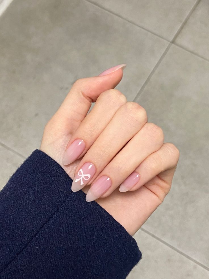 Sophisticated Ombre Nail Design with Tapered Tips and Charming Bow Accent.