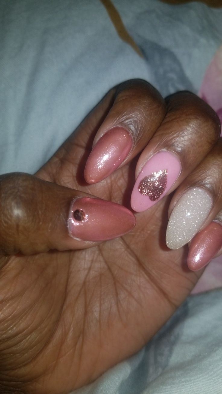 Chic Nail Design: Soft Pink and Glitter Accents with Unique Textures and Heart Shapes.