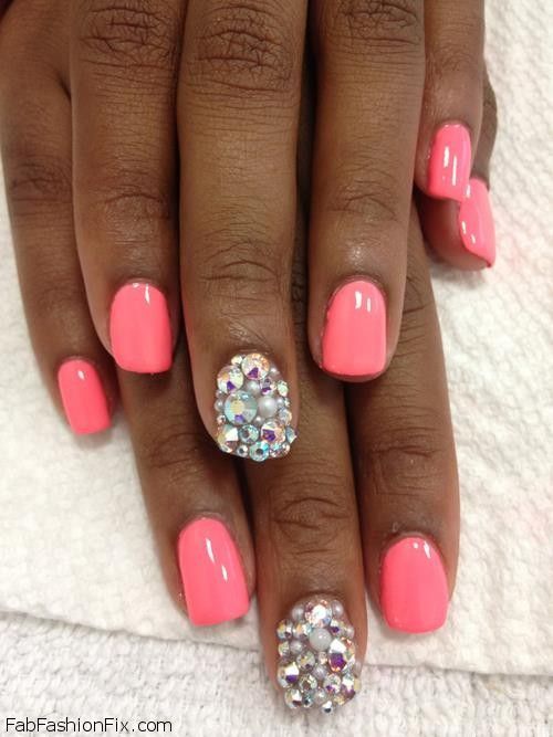 Vibrant Coral Nail Design with Glamorous Rhinestone Accent for Special Occasions.