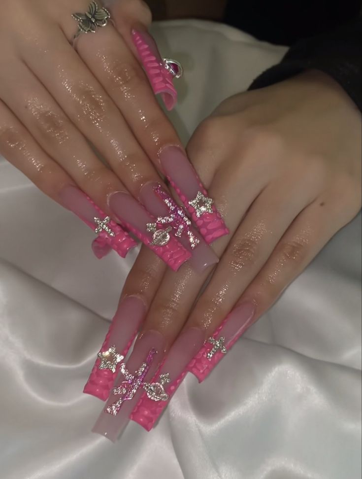 Elegant Playful Stiletto Nail Design with Glossy Pink Finish and Sparkly Embellishments