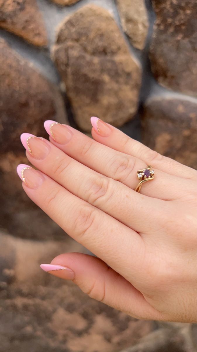 Sophisticated Nude and Pink French Tip Manicure with Glamorous Gold Accents.