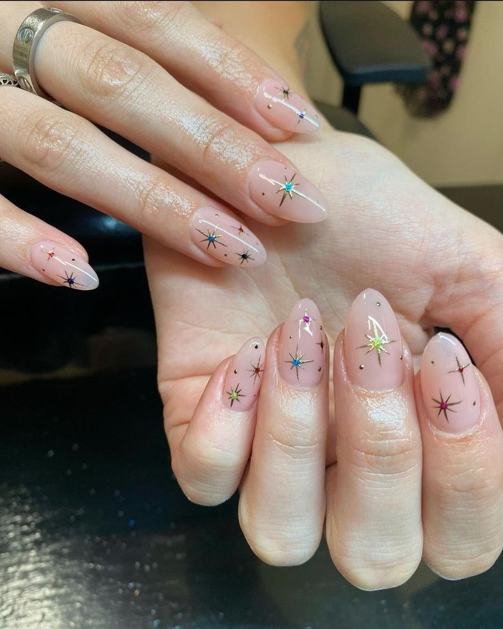 Chic Stiletto Nail Design: Soft Nudes and Whimsical Star Motifs.