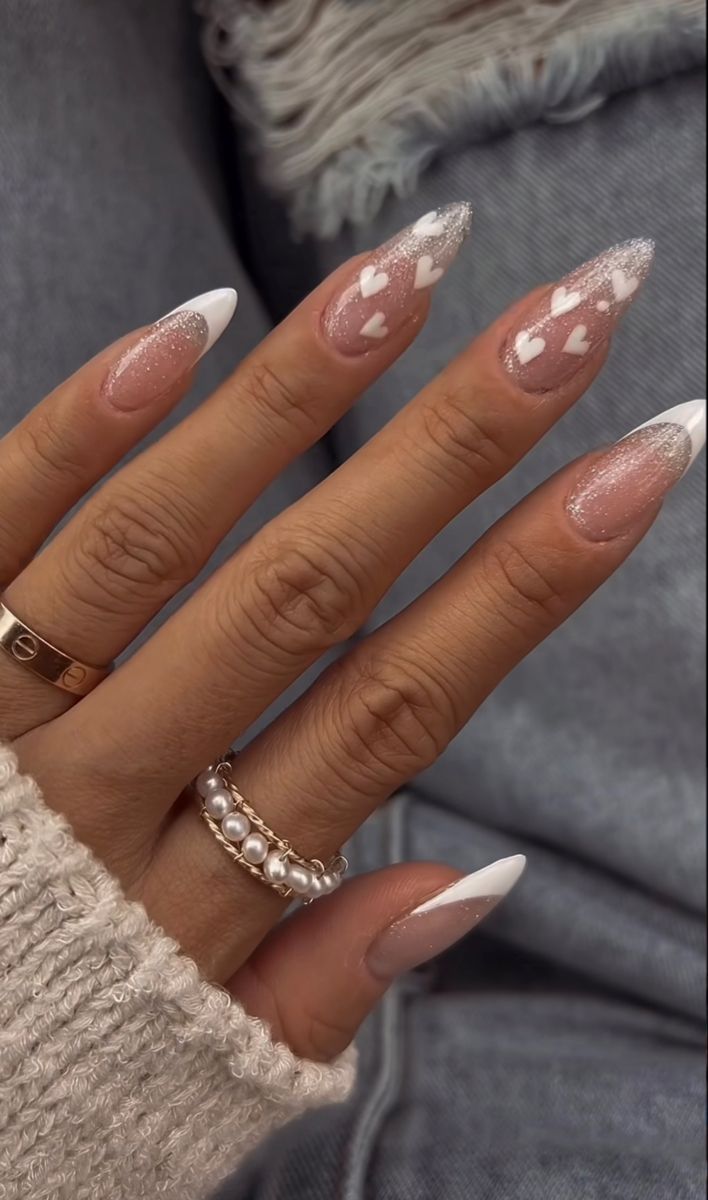 Chic Soft Nude Nail Design with Glitter Tips and Heart Accents.