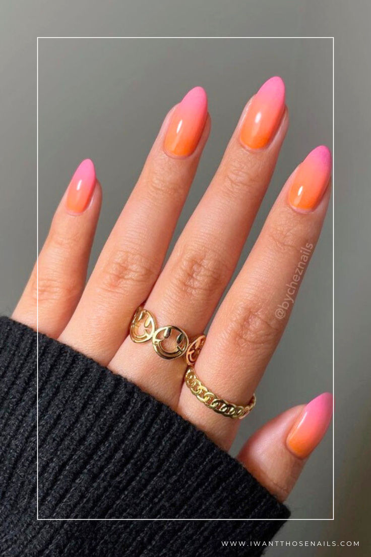 Chic Ombre Nail Design: Coral and Pink Hues on Elegant Almond Shapes with Gold Accents.