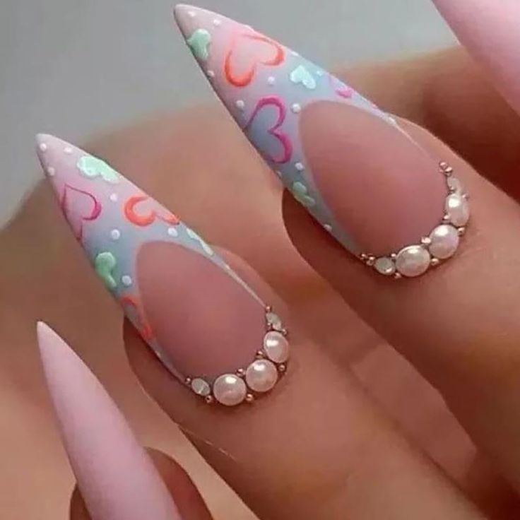 Playful Pastel Heart Patterns on Elongated Stiletto Nails for a Romantic Aesthetic.