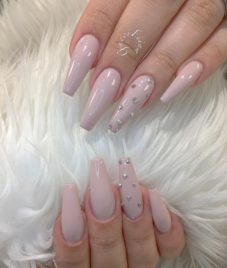 Sophisticated Soft Pink Nail Design with Tapered Shapes and Shimmering Rhinestone Accents.