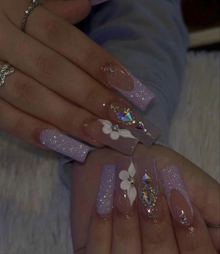 Glamorous Lavender Glitter Nail Design with Gemstone and Floral Accents.