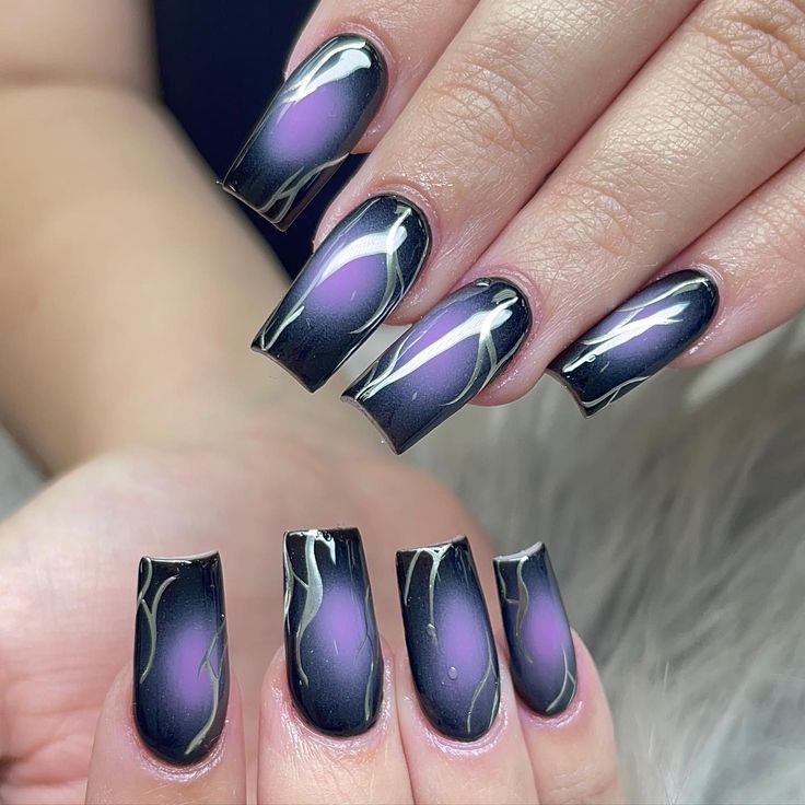 Chic Long Nails with Black Polish, Gradient Purple Accents, and Elegant Gold Marble Swirls.