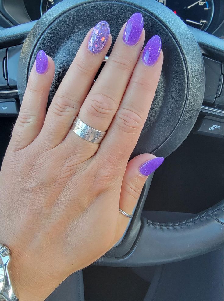 Chic Vibrant Purple Nail Design with Glossy and Glitter Finishes, Accented by Silver Rings