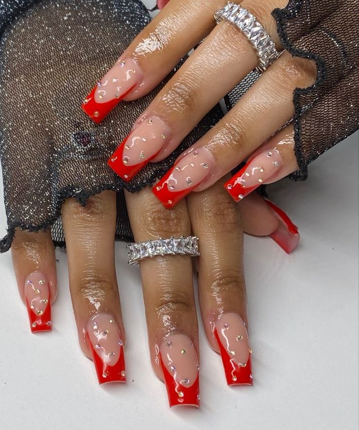 Bold Red Acrylic Nails with Glossy Finish and Elegant Decorative Accents.