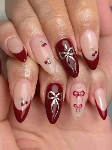 Sophisticated and Playful Deep Red and Nude Nail Design with Intricate Embellishments.