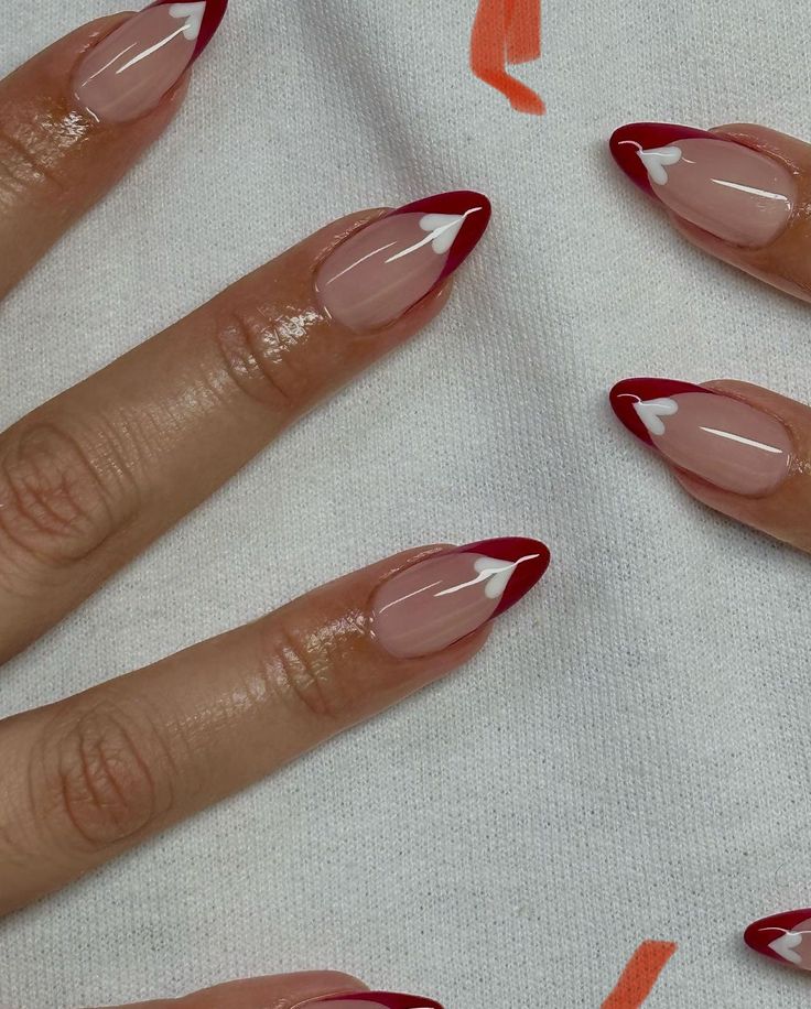 Chic Almond-Shaped Manicure with Red Tips and Playful Heart Accents.