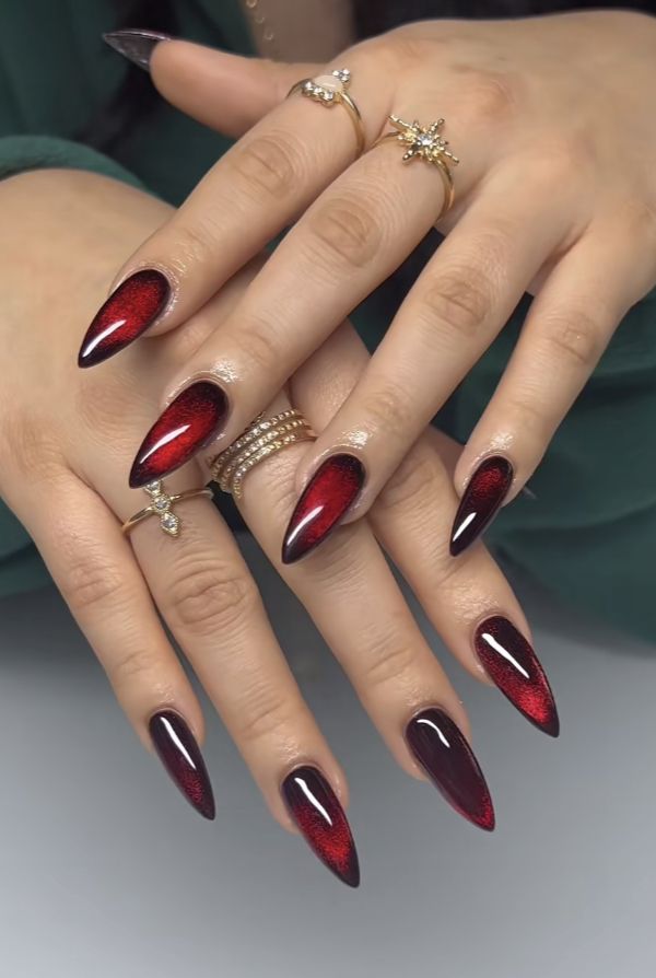 Elegant Almond-Shaped Red Nail Design with Gradient and Gold Accents.