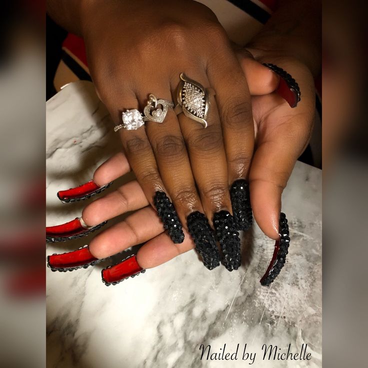 Elegant Elongated Nail Design in Black and Deep Red with Glamorous Rhinestones.