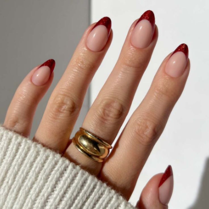 Chic Nude and Red Glitter Nail Design Enhanced with a Sophisticated Gold Ring.