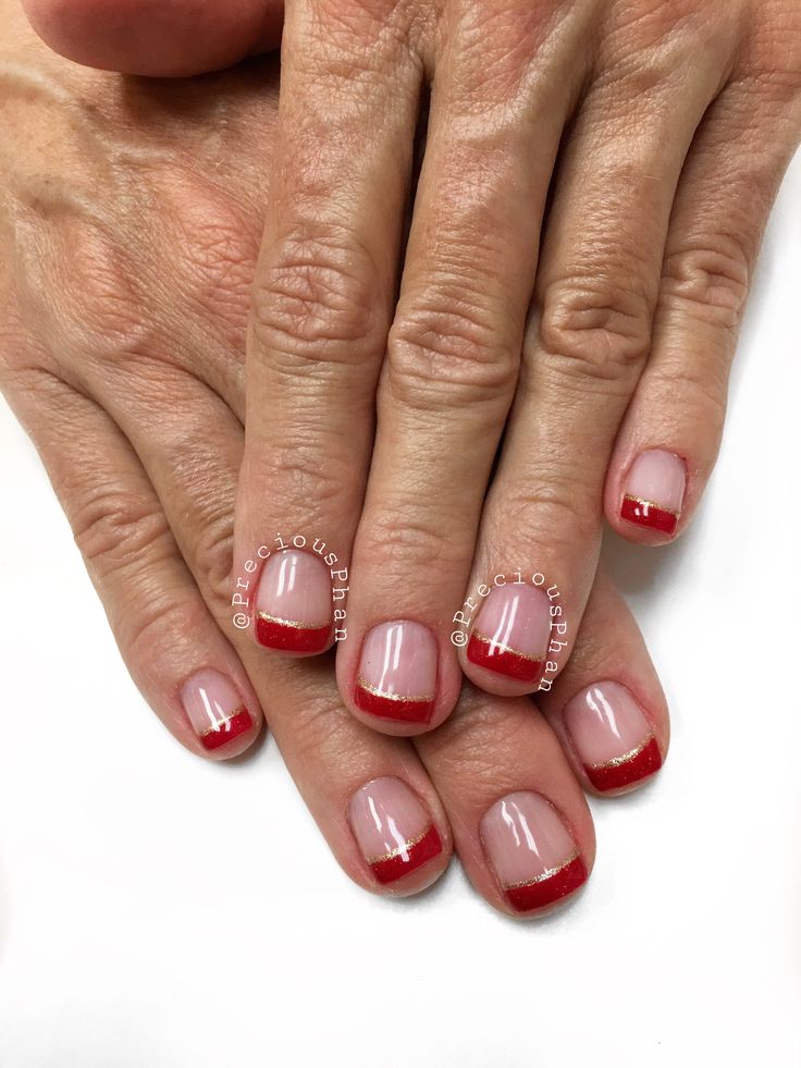 Chic Nude Nail Design with Bold Red Tips and Glamorous Gold Accents