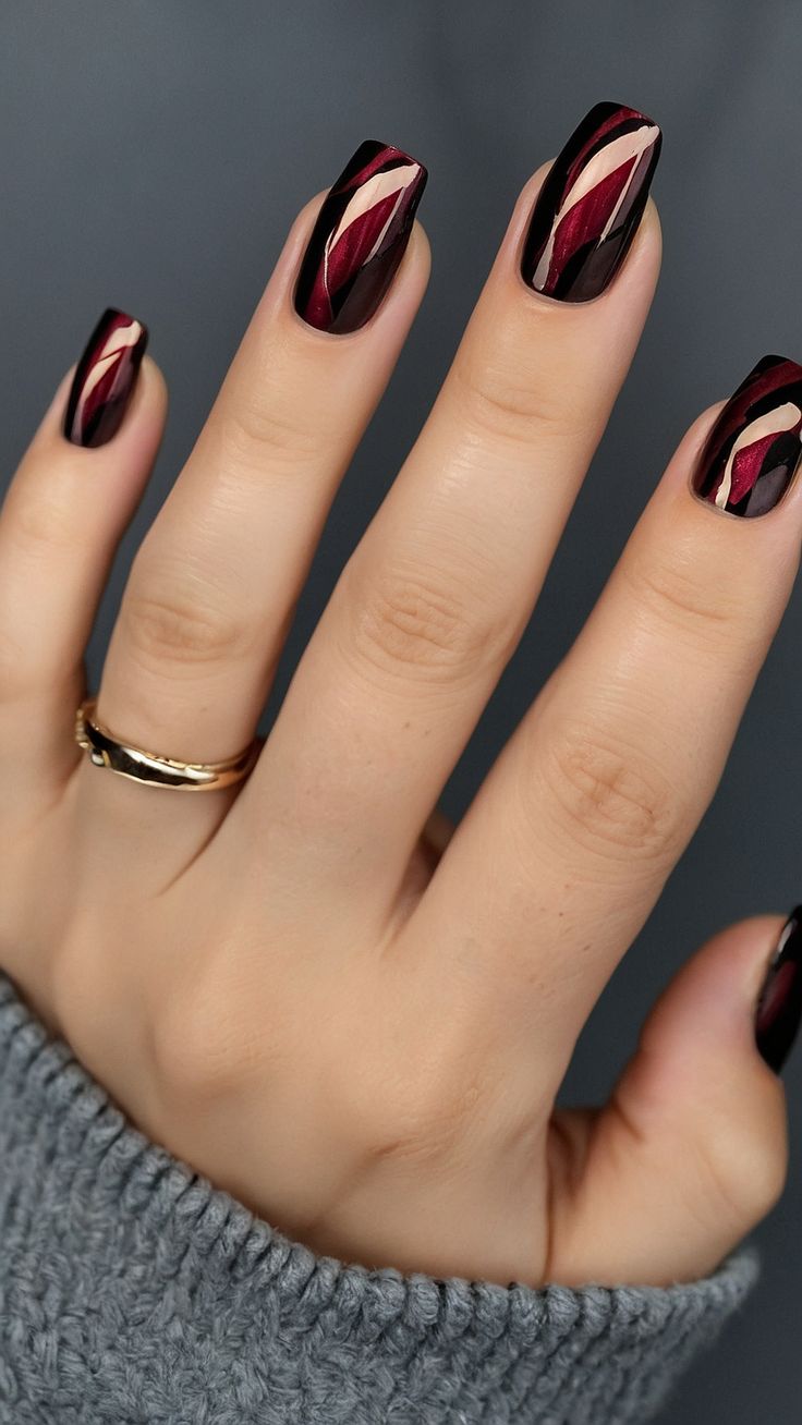 Elegant Black Nail Design with Maroon and Gold Geometric Accents