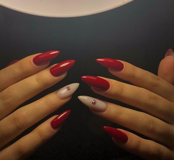 Elegant Almond-Shaped Nail Design in Bold Red and Gray with Unique Playful Detailing.