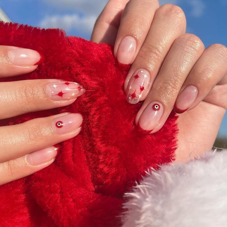 Chic Nail Design: Sheer Pink and Red Accents with Playful Star Motifs for a Festive Elegance.