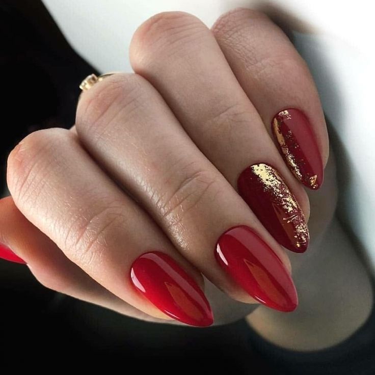 Luxurious Red Almond Nail Design with Glossy, Textured Finishes and Gold Foil Accent.