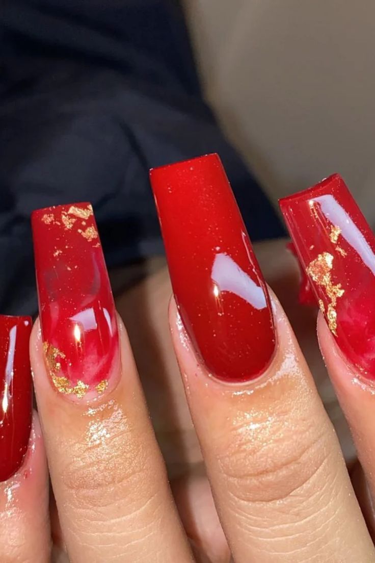 Elegant Red Nail Art with Glossy Finish and Gold Foil Accents for a Luxurious Look.