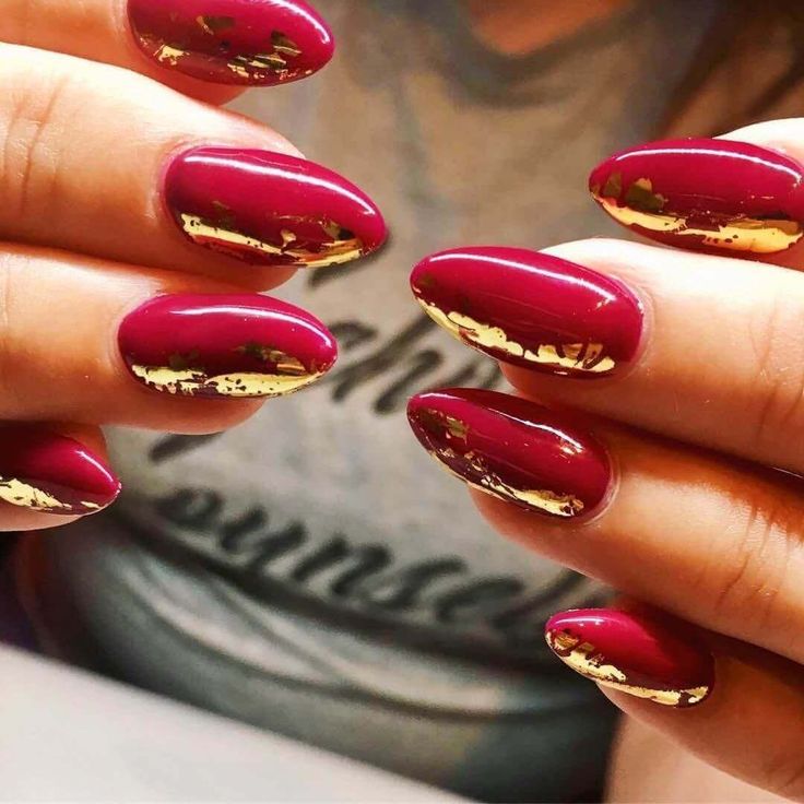 Striking Burgundy Almond Nails with Glamorous Gold Foil Accents.