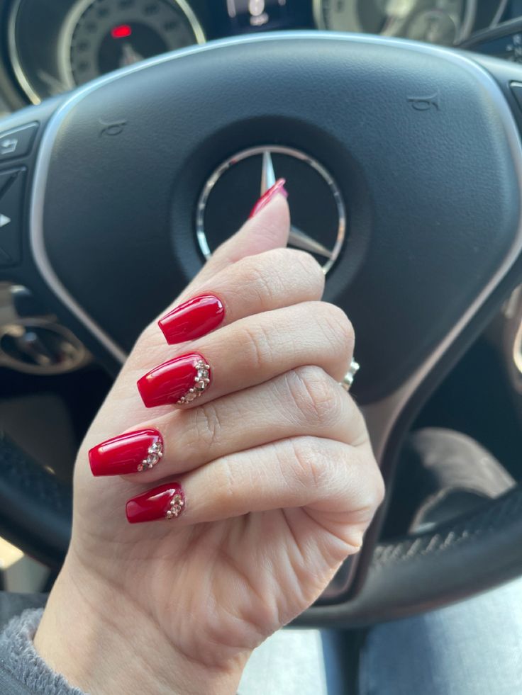 Chic Red Manicure with Glossy Finish and Sparkling Embellished Tips.