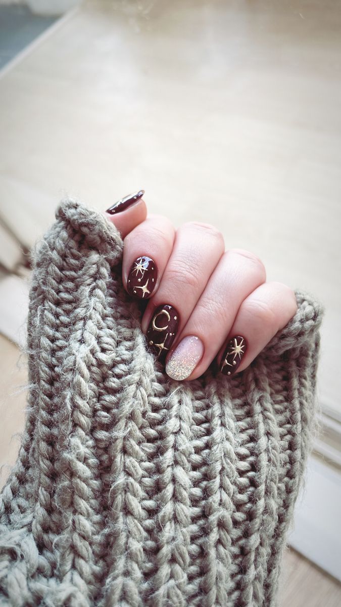 Chic Autumn Nail Design with Burgundy Base and Celestial Patterns