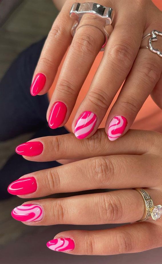 Bold Glossy Pink Nails with Trendy Swirl Accents for a Stylish Manicure.