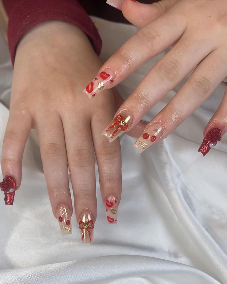 Whimsical Holiday Nail Design: Vibrant Reds and Soft Golds with 3D Bows and Cherries