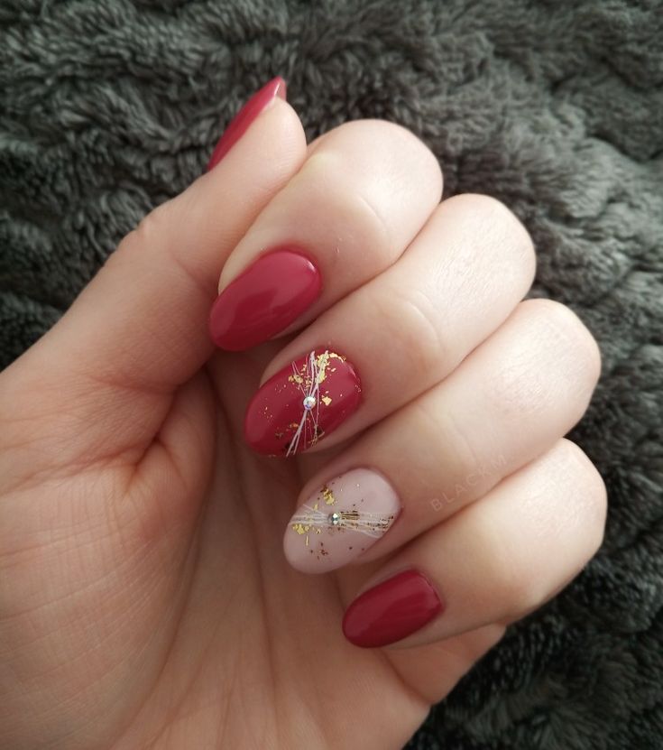 Chic Deep Red and Soft Pink Nail Design with Glamorous Gold Accents and Sparkling Gem.