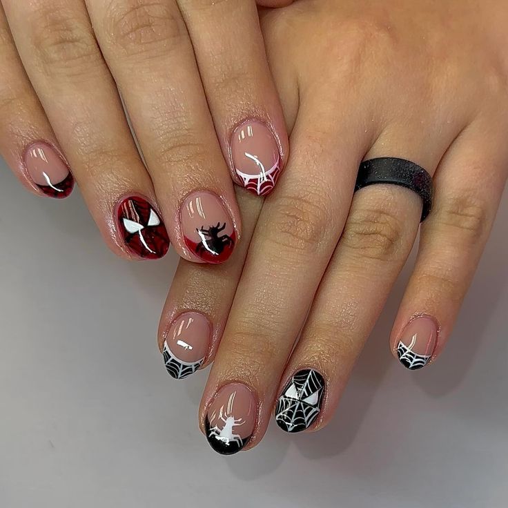 Striking Spider-Themed Nail Design with Intricate Web Patterns and Playful Motifs in Red, Black, and White.