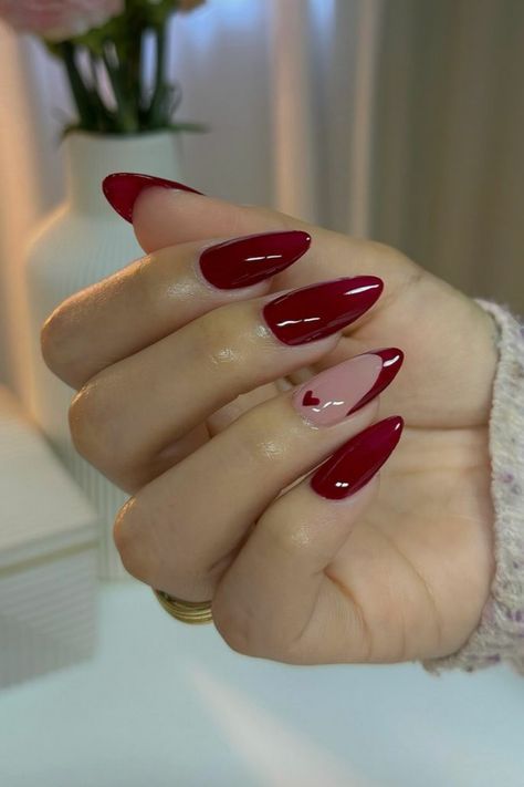 Elegant Nail Design: Sophisticated Pointed Shape with Deep Red and Soft Pink Shades, Enhanced by a Playful Heart Accent.