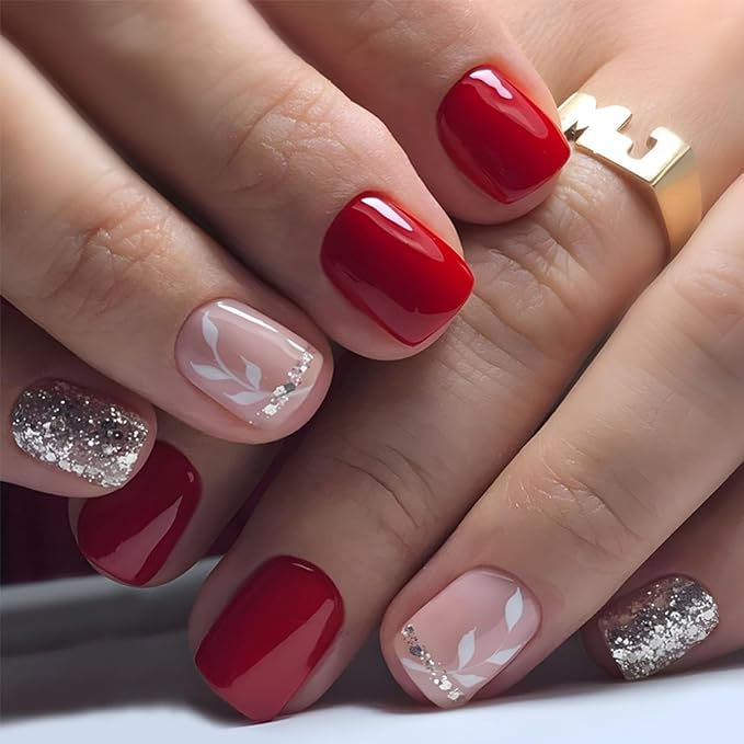 Chic Nail Art: Bold Red and Subtle Nude with White Leaf Patterns and Glitter Tips.