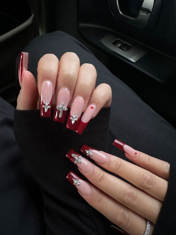 Sophisticated Nail Design: Deep Red and Soft Nude with Rhinestones and Long Glossy Tips.