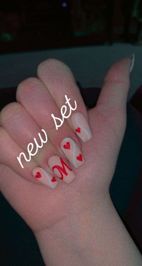 Elegant Nude Nail Design with Vibrant Red Hearts and Whimsical Letter Accents