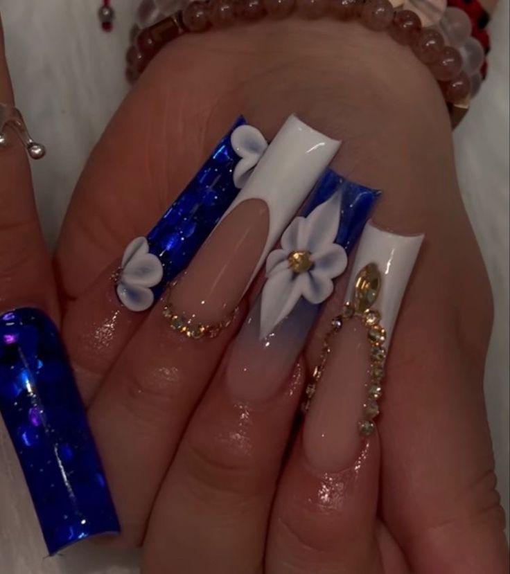 Elegant Blue and White Stiletto Nail Design with Floral Accents and Gold Details.