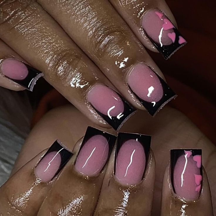 Trendy Chic Nail Design: Soft Pink Base with Bold Black Tips and Playful Pink Heart Accents