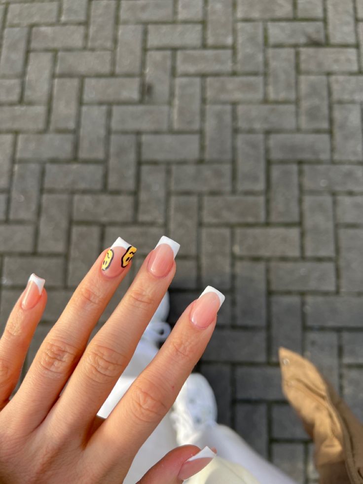 Chic Gel Manicure with Classic French Tips and Playful Yellow Graphic.