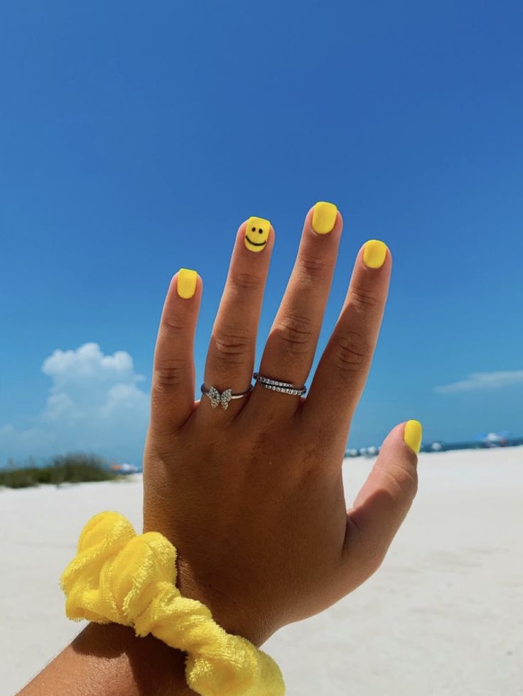 Playful Bright Yellow Nail Design with Smiley Face for Summer Fun