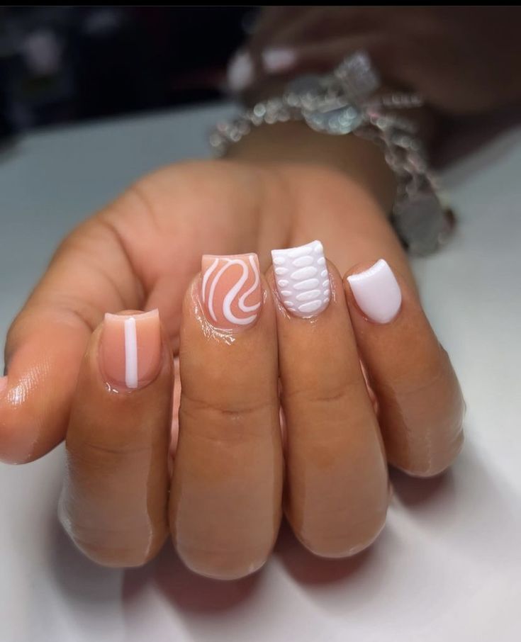 Chic Nail Design: Intricate Soft Pink and White Swirls with Textured Accents.