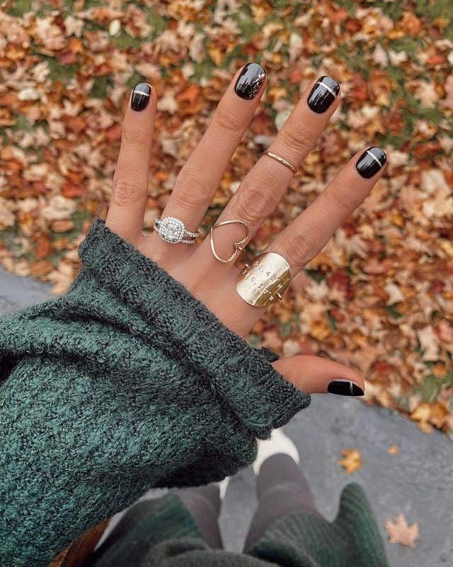 Chic Black Nail Design with Sophisticated Accents: A Seasonal Fashion Statement.