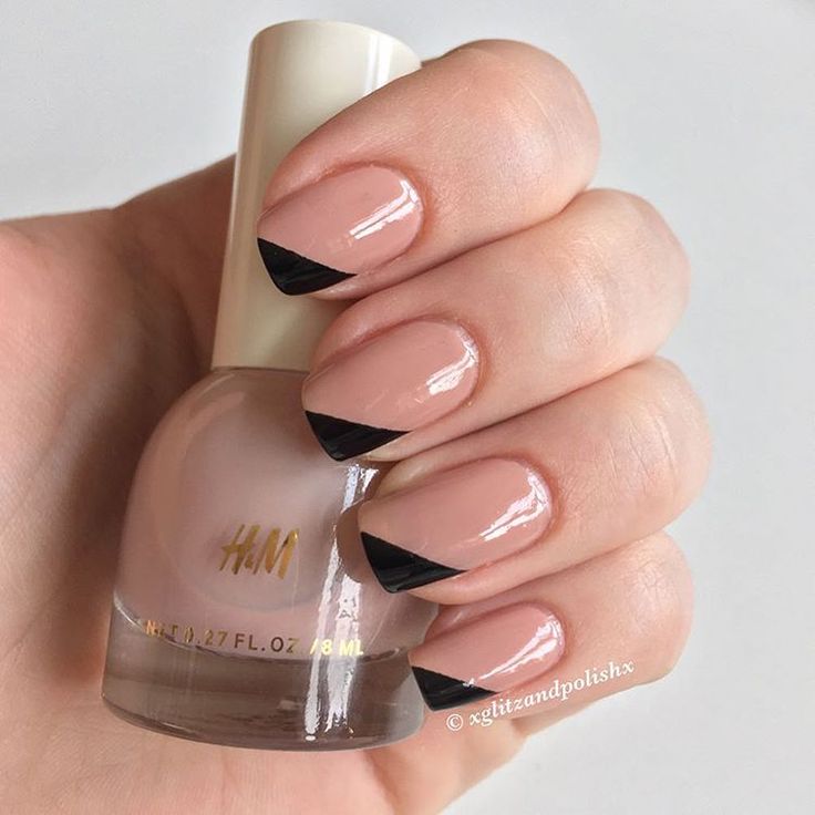 Chic Modern French Manicure: Nude Base with Bold Black Triangular Tips.