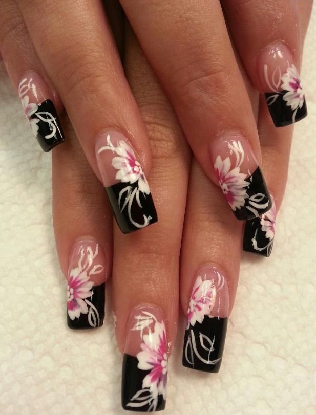 Sophisticated Floral Nail Art: Bold Black Tips with Delicate White and Pink Accents.