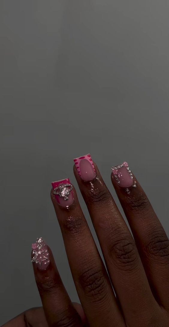 Vibrant Pink and Nude Nail Design with Playful Patterns and Sparkling Gems.