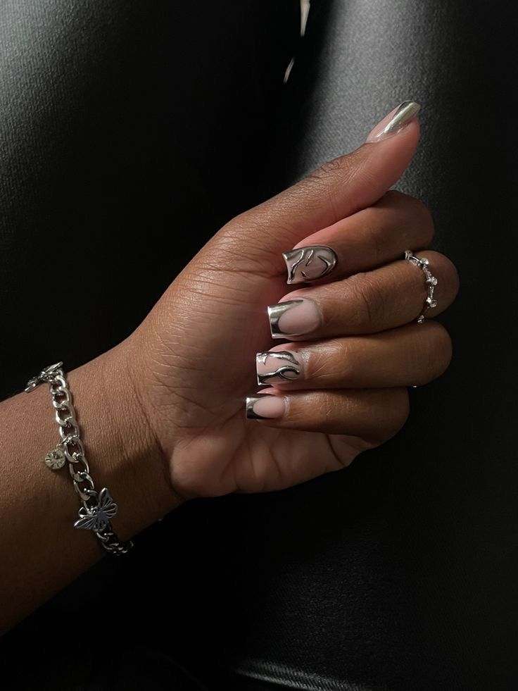 Chic Nail Design: Metallic Silver Tips with Edgy Black Flame Patterns and Complementary Accessories