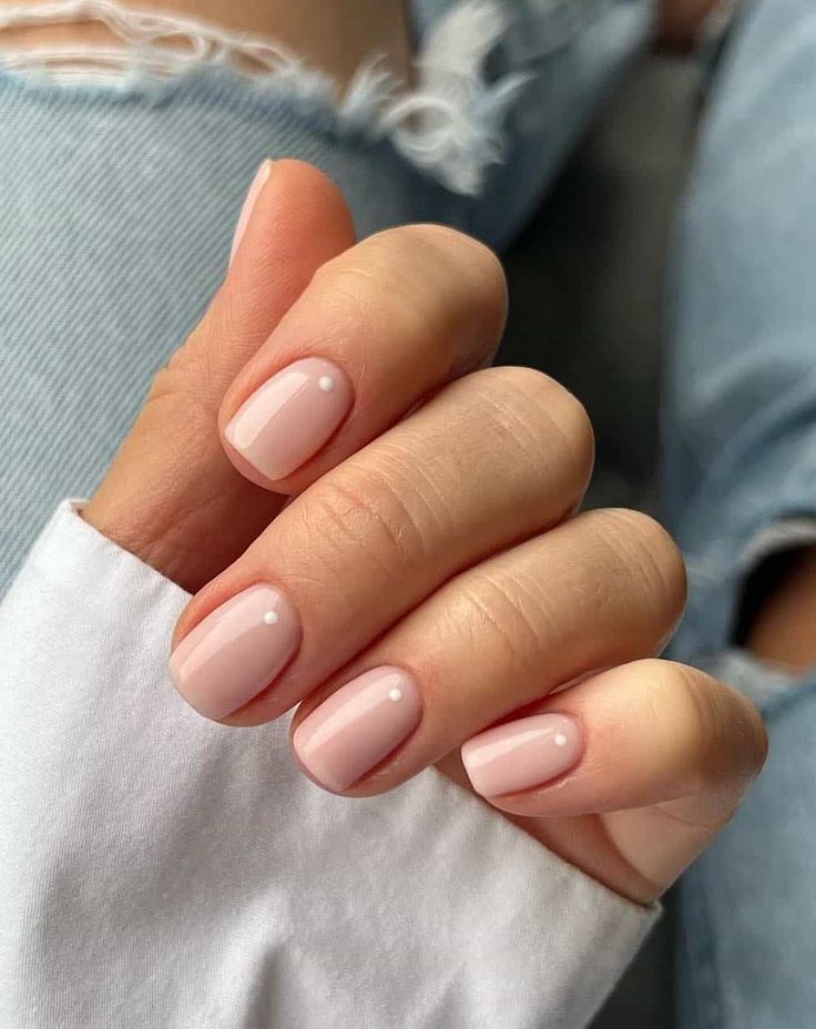 Sophisticated Nude Manicure with Glossy Finish and Delicate Pearl Embellishments.